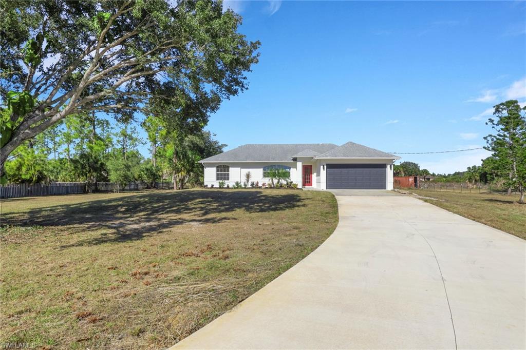 Single story home with concrete driveway and an attached garage