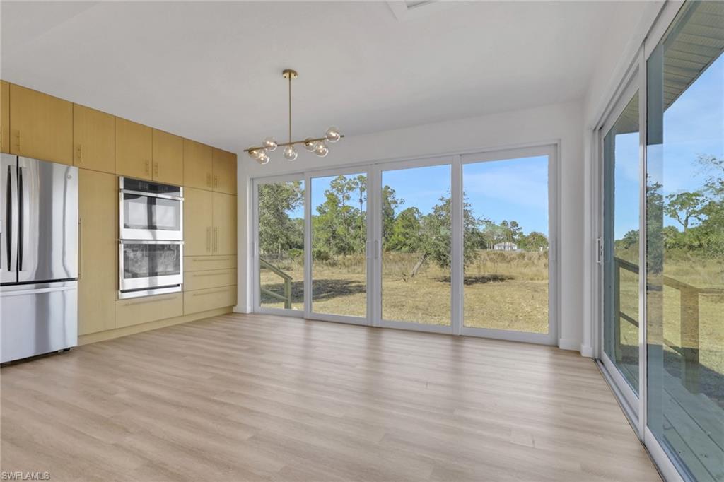Unfurnished dining area featuring a chandelier and light wood finished floors