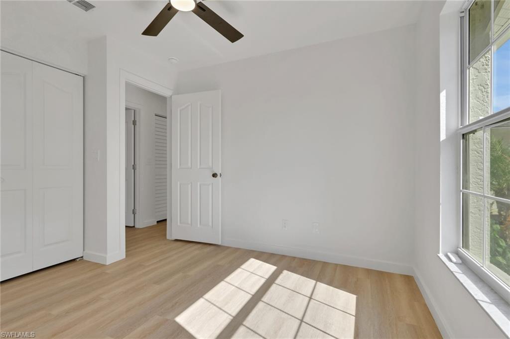 Unfurnished bedroom with light wood-type flooring, ceiling fan, and a closet