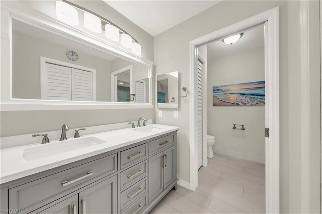 Full bath with double vanity and toilet