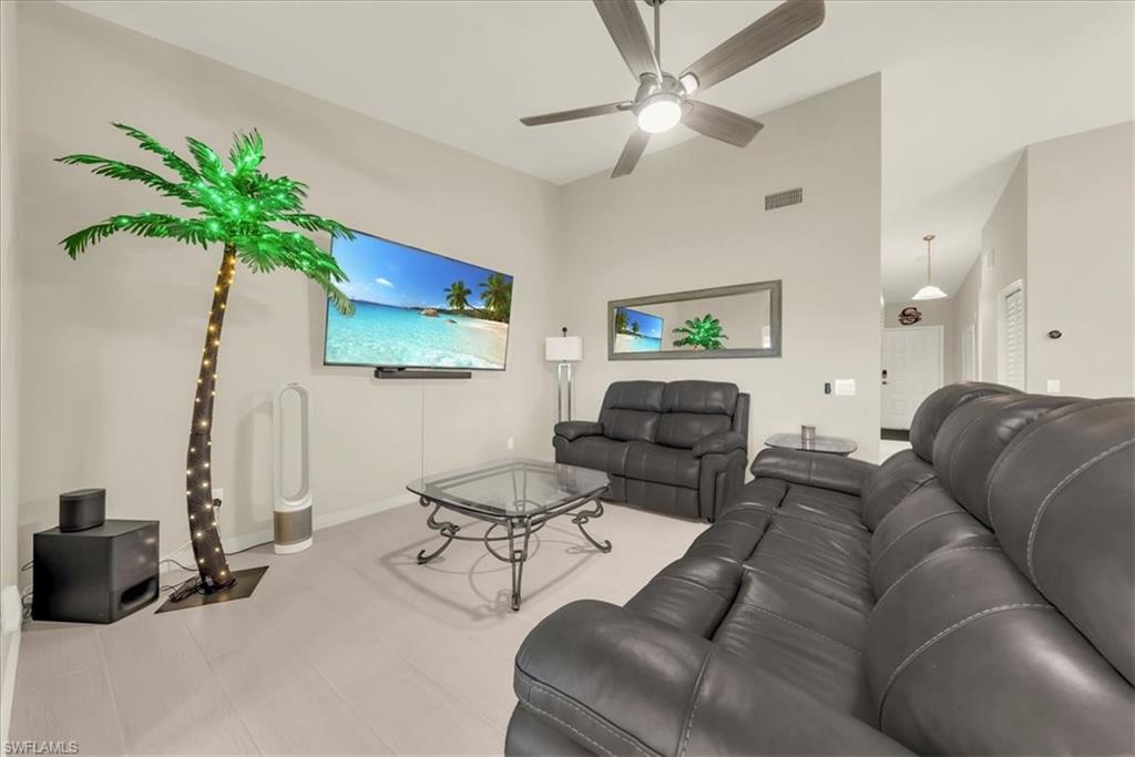 Living area featuring ceiling fan and high vaulted ceiling