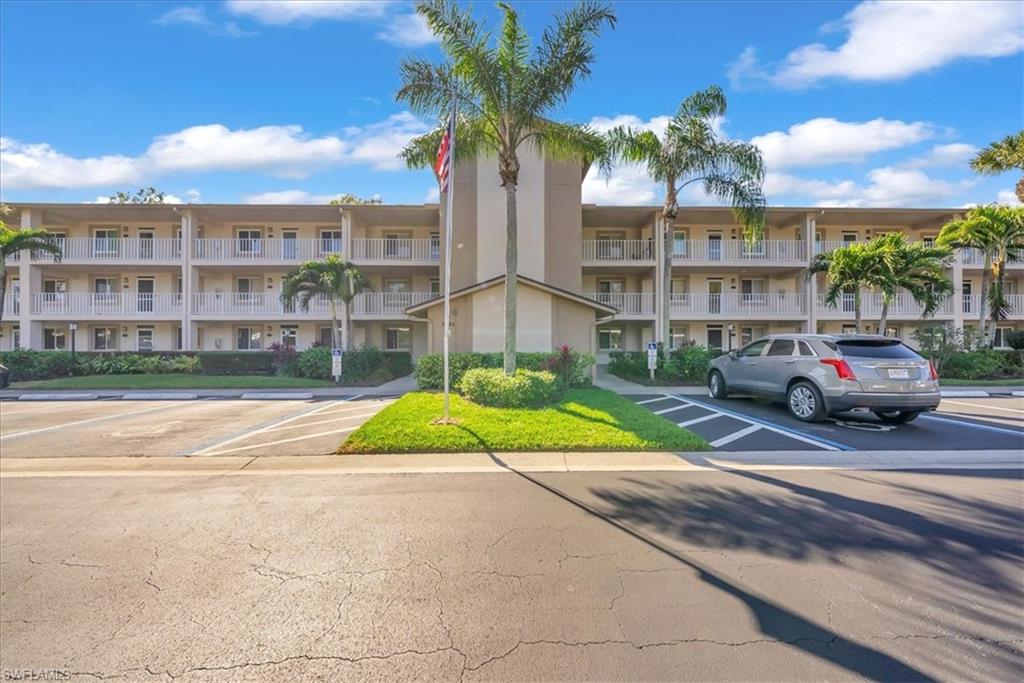 View of apartment building / complex with uncovered parking