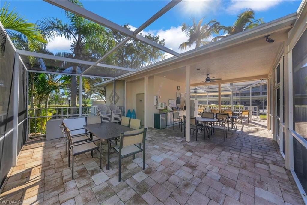 View of patio featuring outdoor dining area, a sunroom, glass enclosure, and ceiling fan