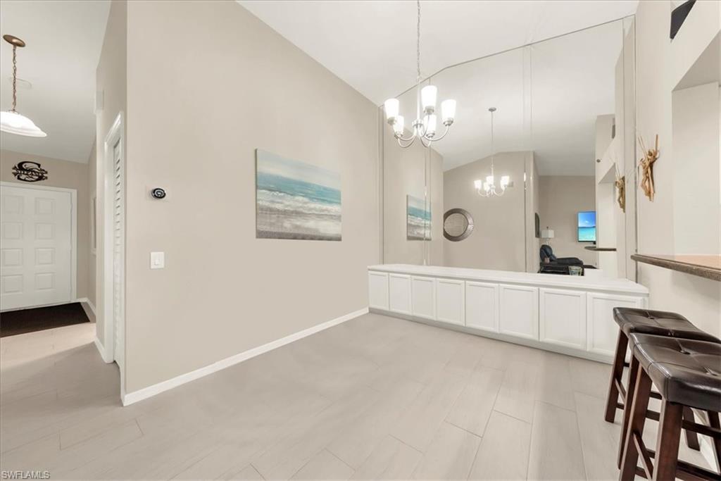 Bathroom featuring lofted ceiling, double vanity, and a chandelier
