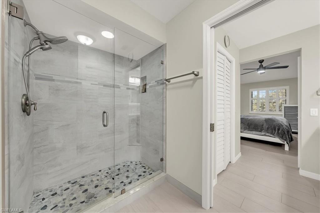 Ensuite bathroom featuring a shower stall and a ceiling fan