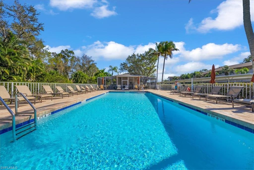 Community pool with a patio area and a sunroom