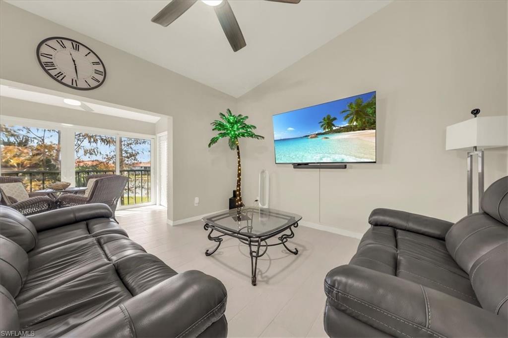 Living area with ceiling fan and high vaulted ceiling