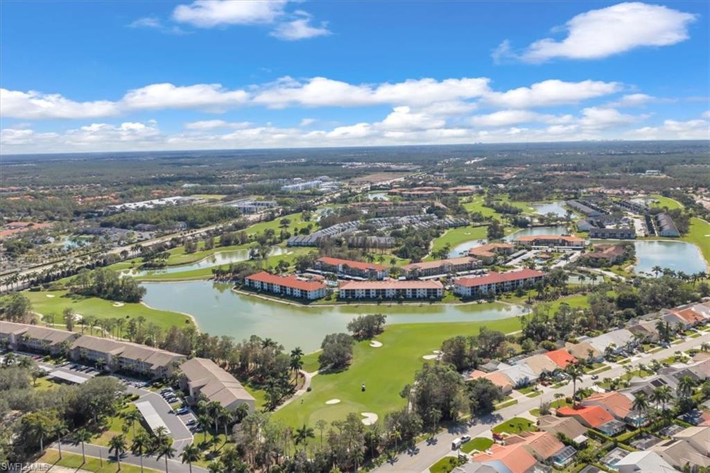 Aerial view of property's location featuring a local golf course, a large body of water, and nearby suburban area