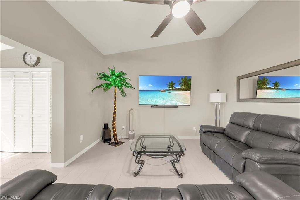 Living room featuring vaulted ceiling and ceiling fan