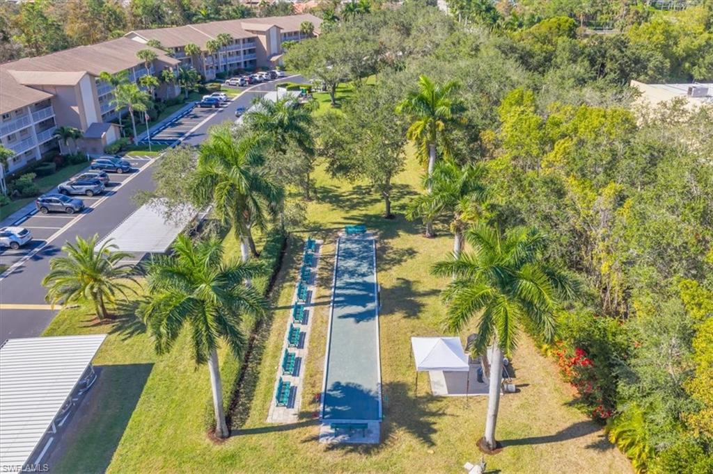 Drone / aerial view of apartment complex / building and a tree filled landscape