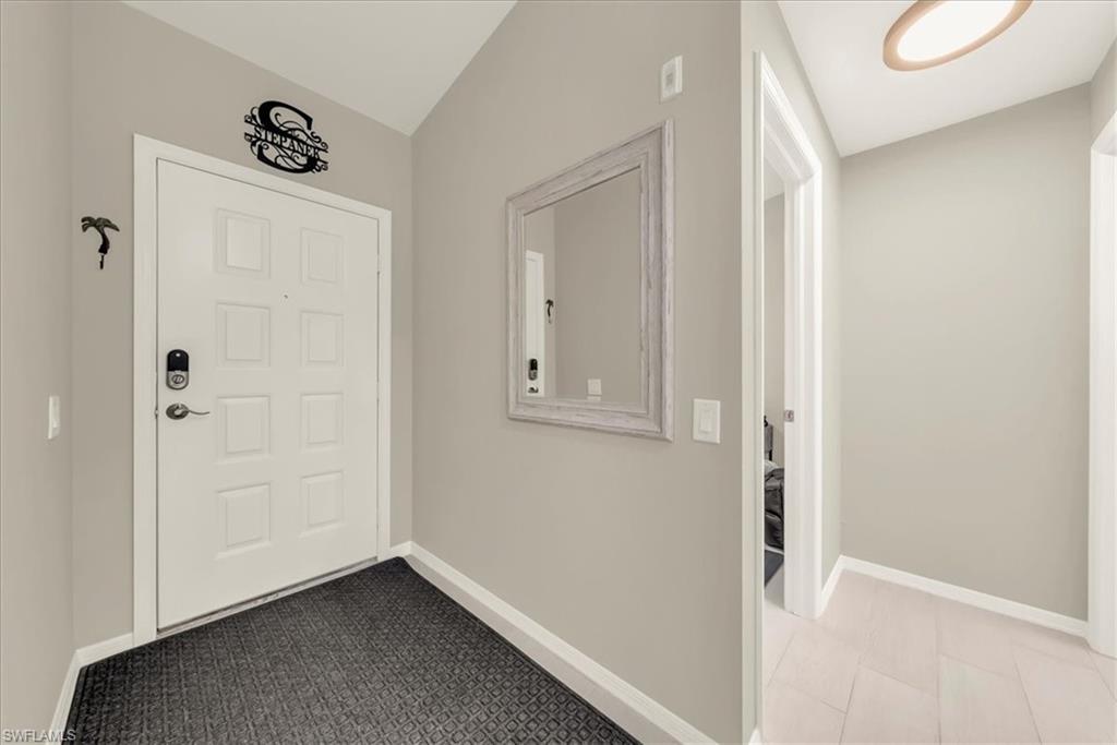Entrance foyer featuring baseboards and light carpet