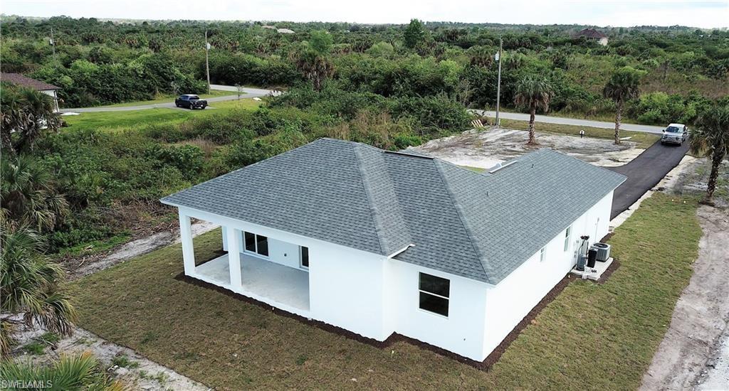 Aerial view of property and surrounding area featuring a heavily wooded area