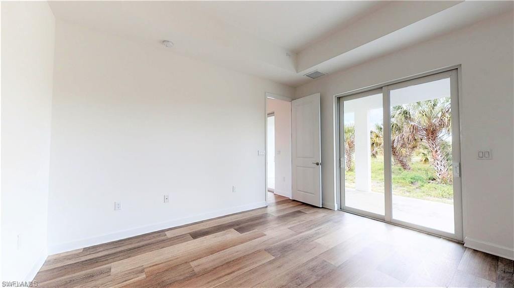 Spare room with baseboards and wood finished floors