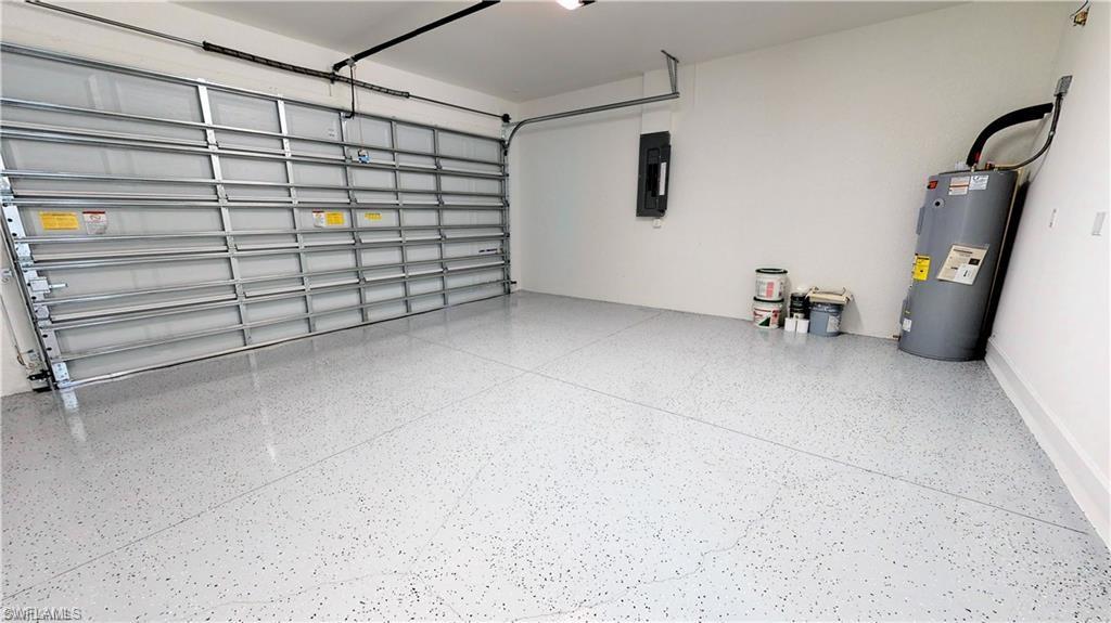 Garage featuring electric water heater and electric panel