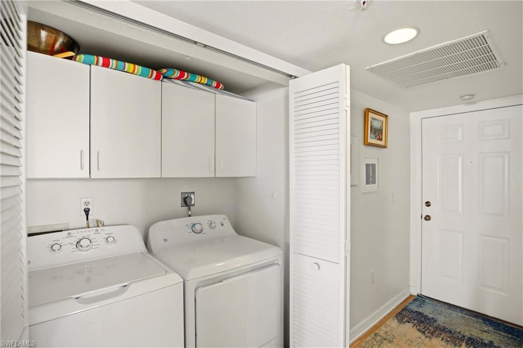 The laundry area offers cabinets for storage.