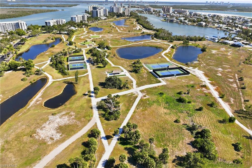 Amenities include walking paths with park benches, a beach access path, tiki huts with picnic tables, tennis courts, pickleball courts, bocce courts, putting green, pitching green, driving cage, fishing pier, and more.