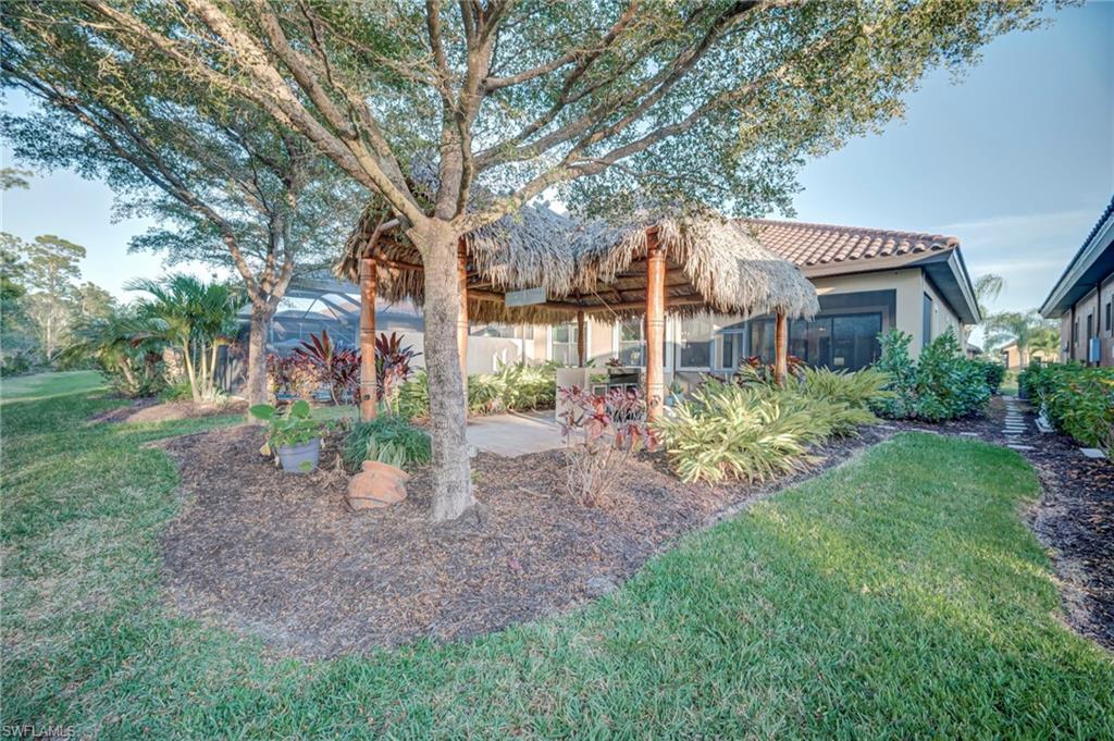 Back of property featuring a yard, a patio, a tiled roof, and stucco siding