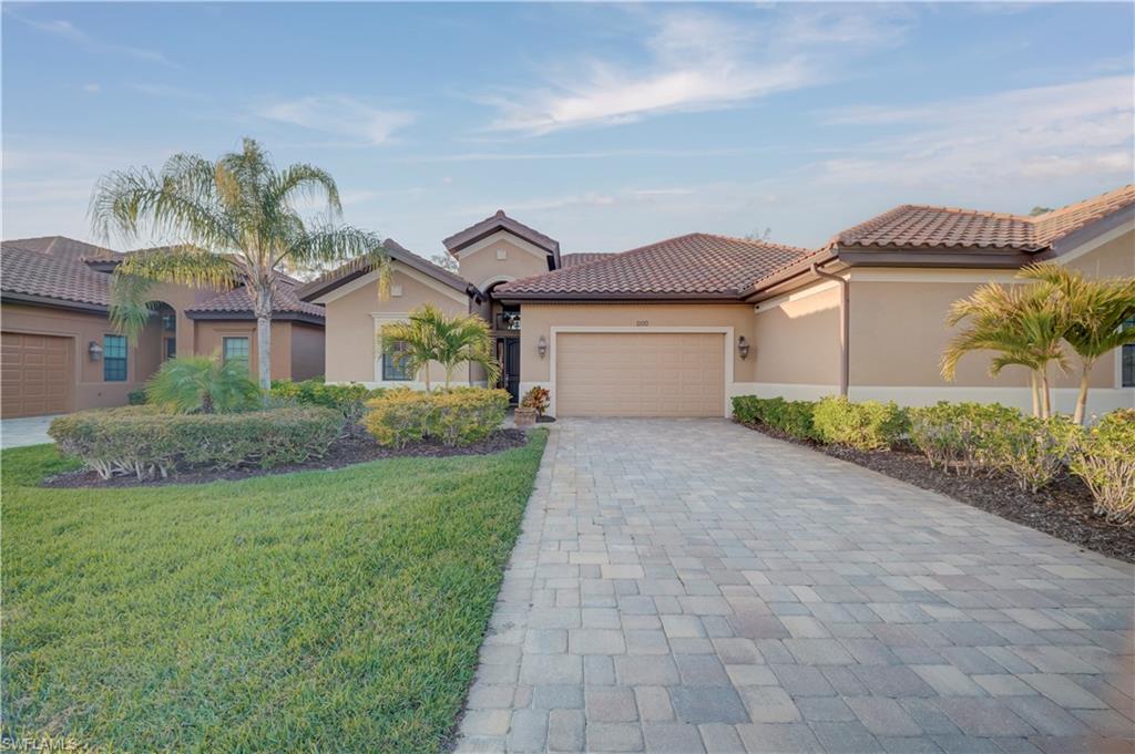 Mediterranean / spanish-style home with an attached garage, stucco siding, decorative driveway, and a tile roof