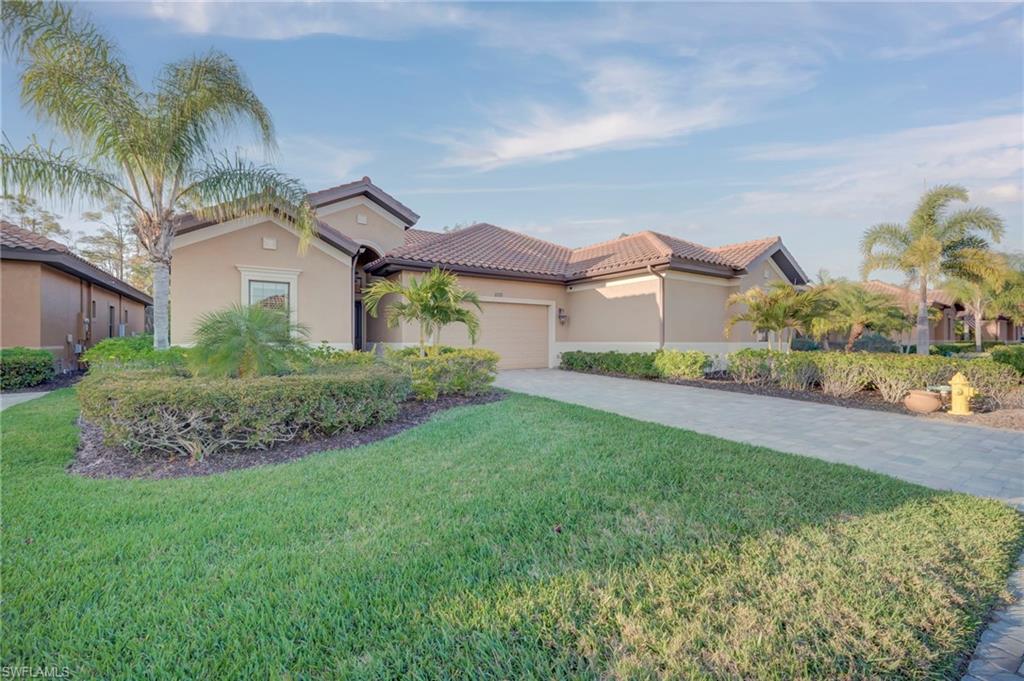 Mediterranean / spanish home featuring a garage, stucco siding, decorative driveway, a front yard, and a tile roof