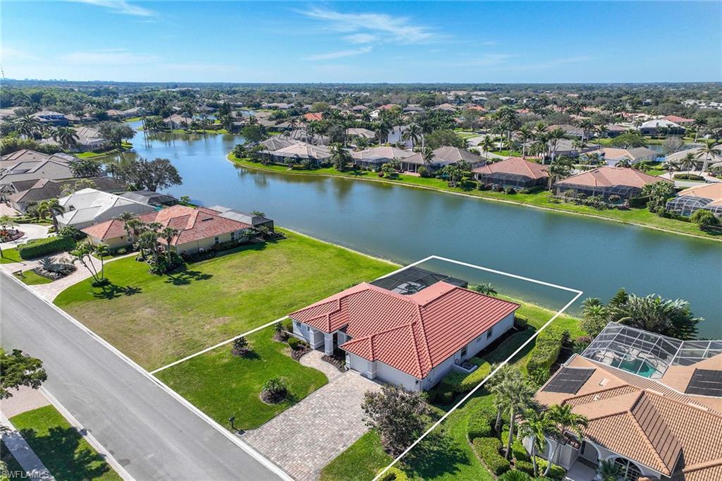 Aerial view of residential area with a nearby body of water and property parcel outlined