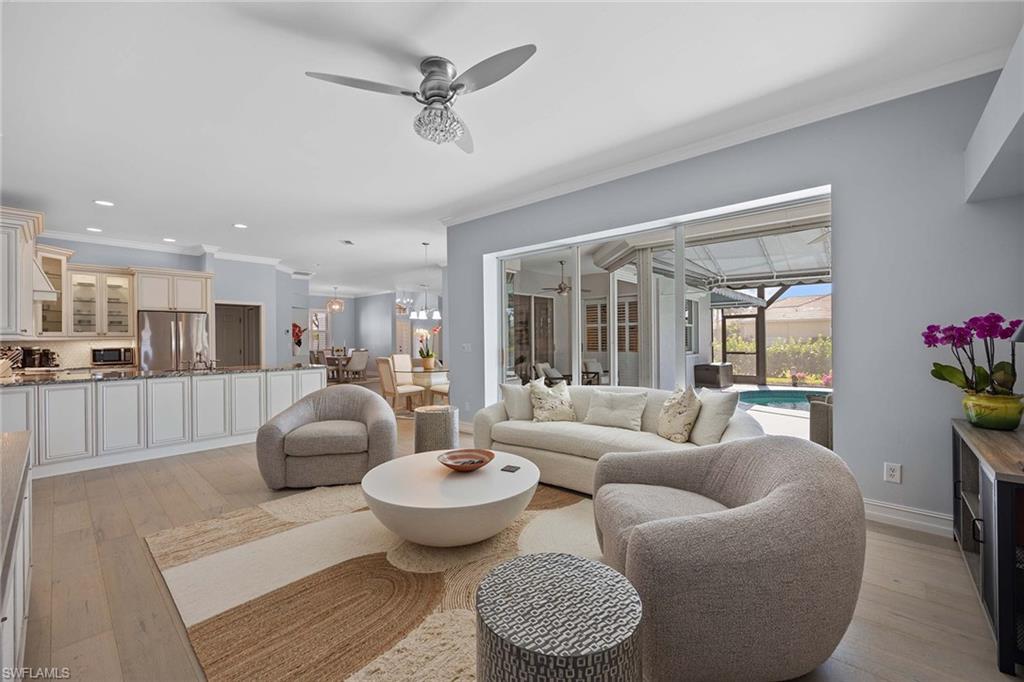 Living area with ornamental molding, a sunroom, ceiling fan, light wood-style flooring, and recessed lighting