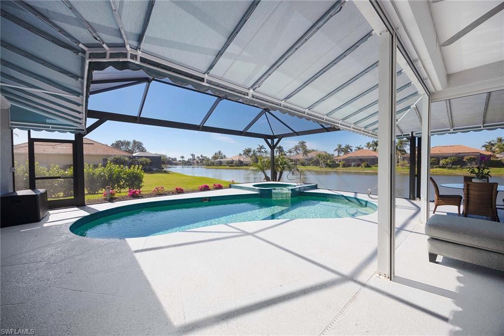 View of swimming pool featuring a lanai, a residential view, a sunroom, a pool with connected hot tub, and a water view