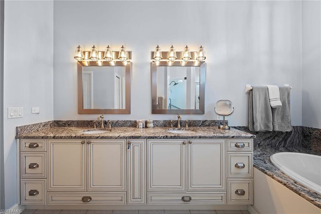 Full bathroom featuring double vanity, a bath, and a shower stall