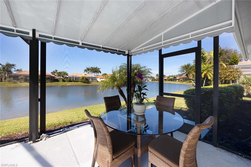 Sunroom with lofted ceiling, a water view, and a residential view