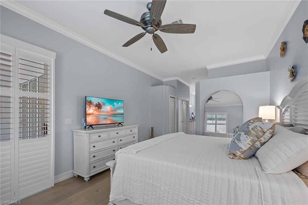 Bedroom with ornamental molding, light wood finished floors, a ceiling fan, and a closet