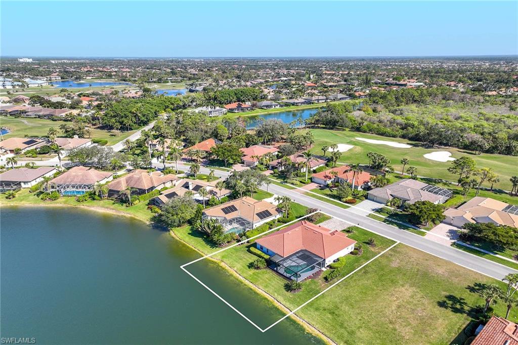 Aerial perspective of suburban area featuring a nearby body of water and a golf club