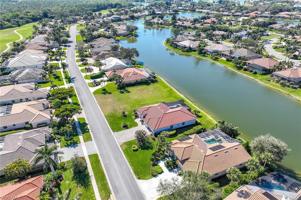 Aerial view of property and surrounding area featuring nearby suburban area and a nearby body of water