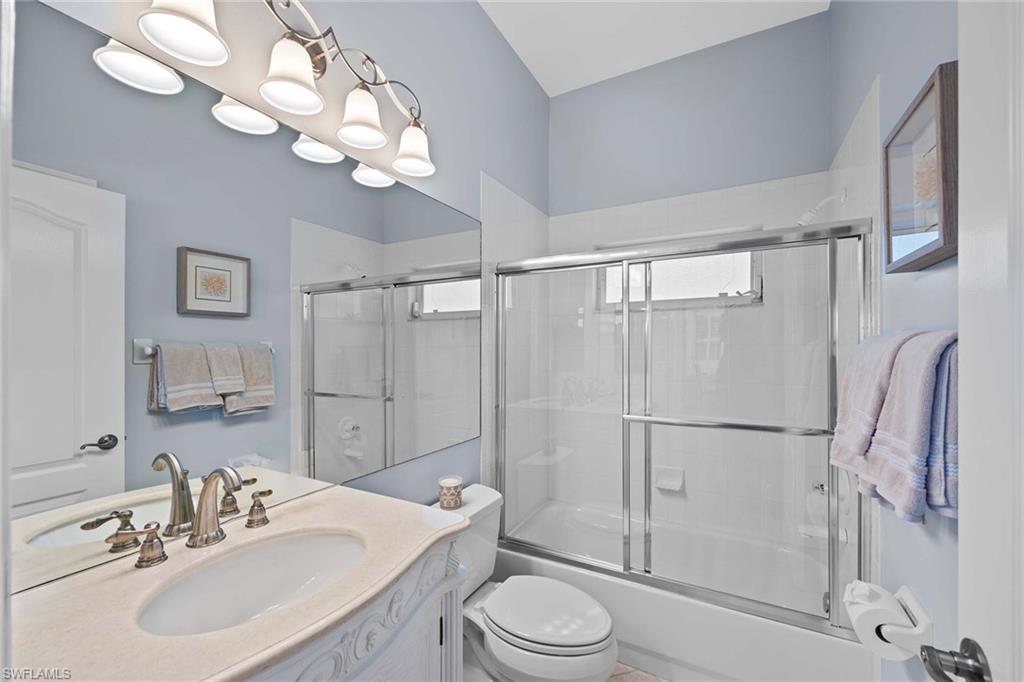 Full bath featuring enclosed tub / shower combo and vanity