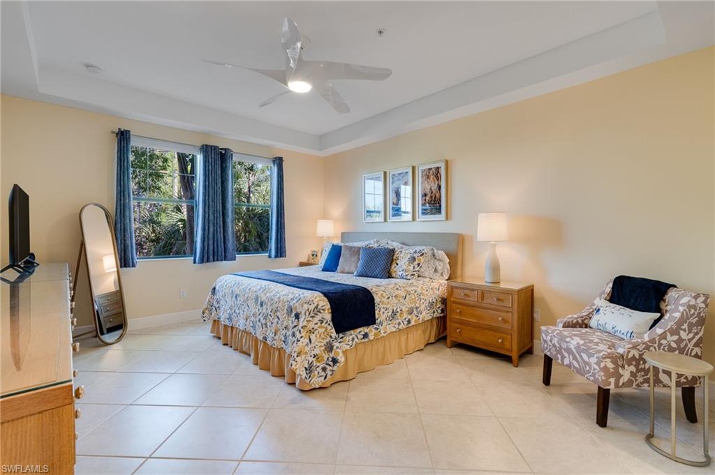 Primary bedroom with a tray ceiling, upgraded ceiling fan, and plenty of room for a king bed and a sitting area.