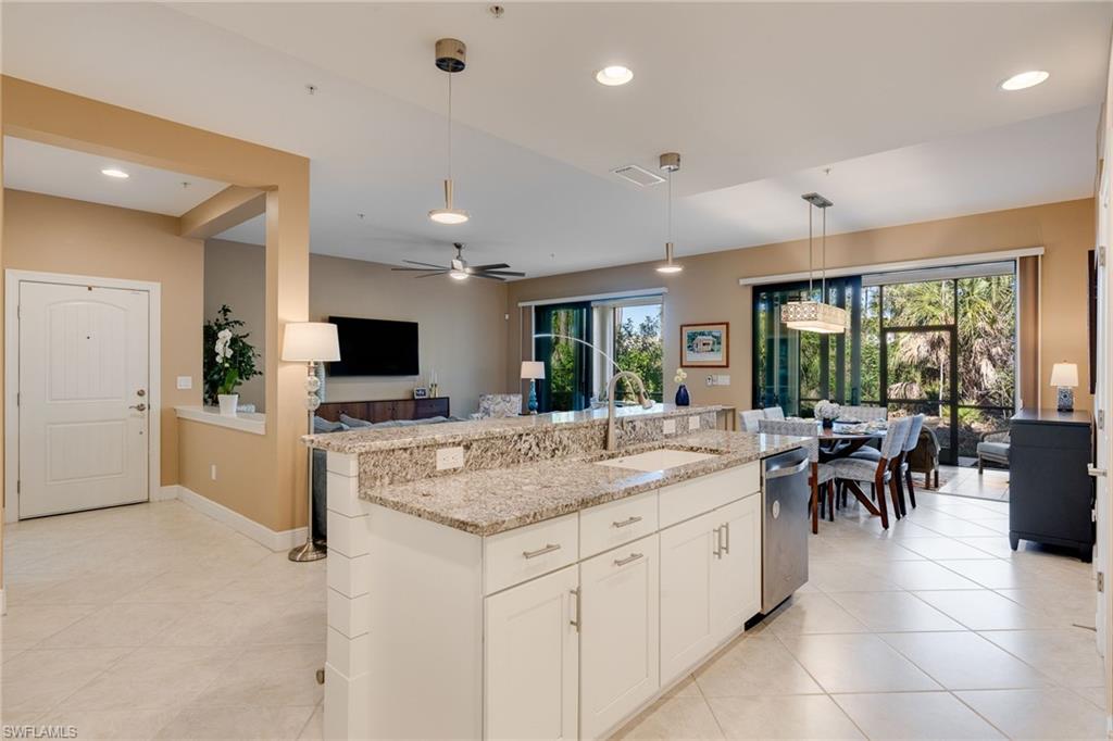 The entrance foyer opens to an expanse of kitchen, living, and dining, with 8-foot sliders overlooking a natural preserve.