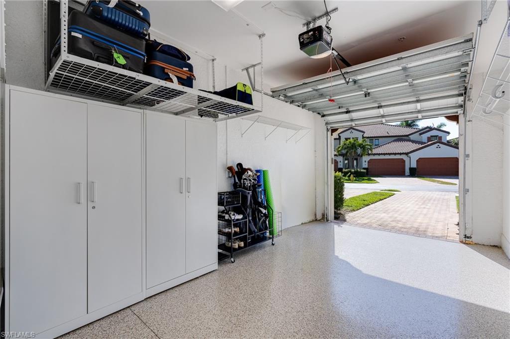 1-Car Garage featuring epoxy floor, tons of shelving, ceiling racks and long driveway.