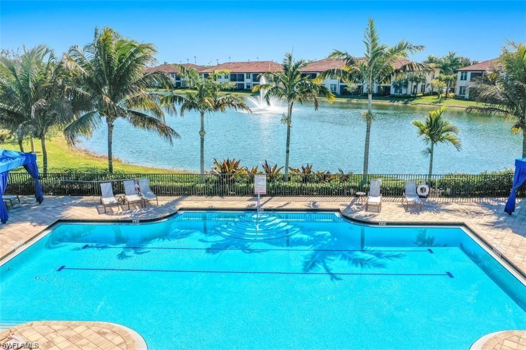 Community pool featuring lap lanes, a patio area and a water view of adjacent lake.
