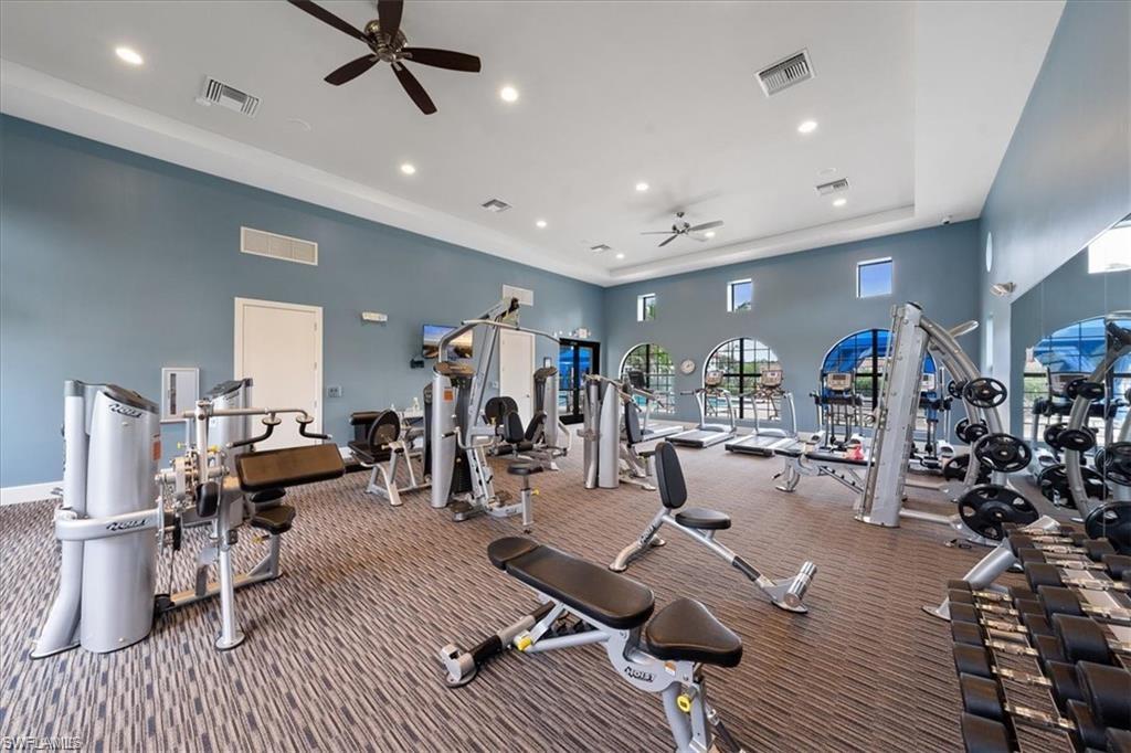 Workout area featuring workout stations, treadmills and free weights and a high tray ceiling