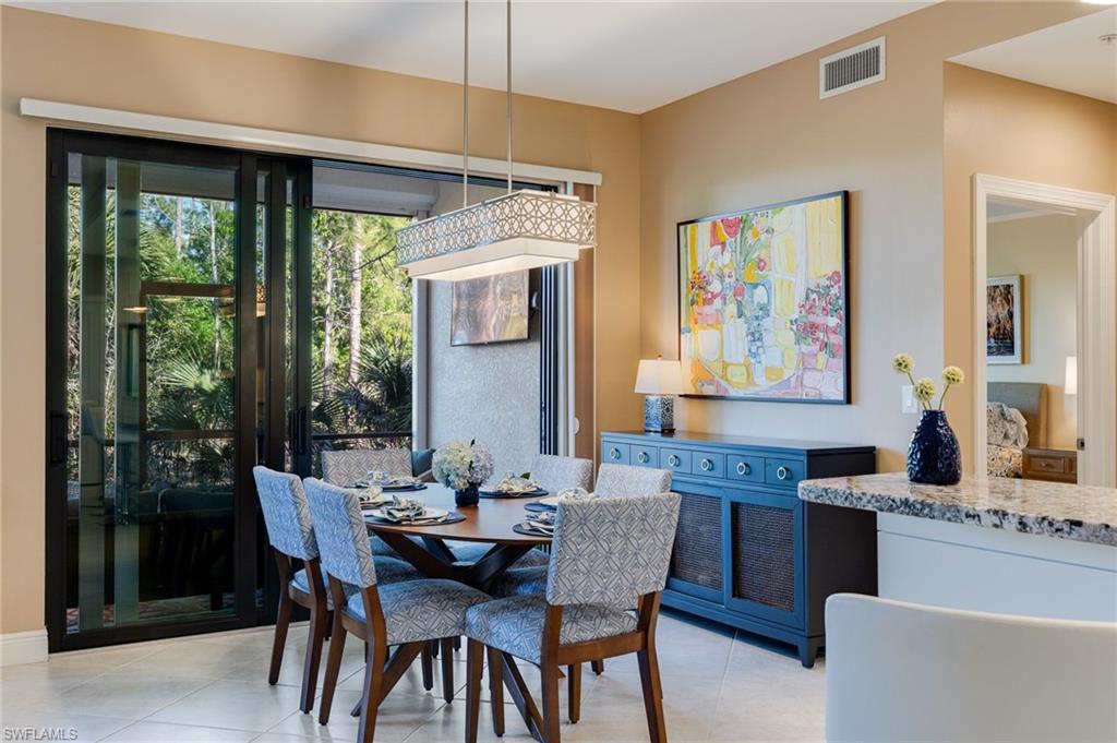 Dining room featuring table for six and custom light fixture.