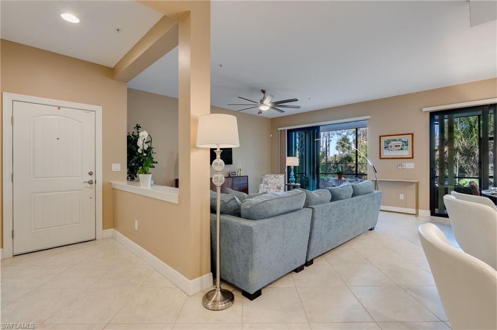 Main entrance and foyer open to the living area featuring a ceiling fan lots of light.