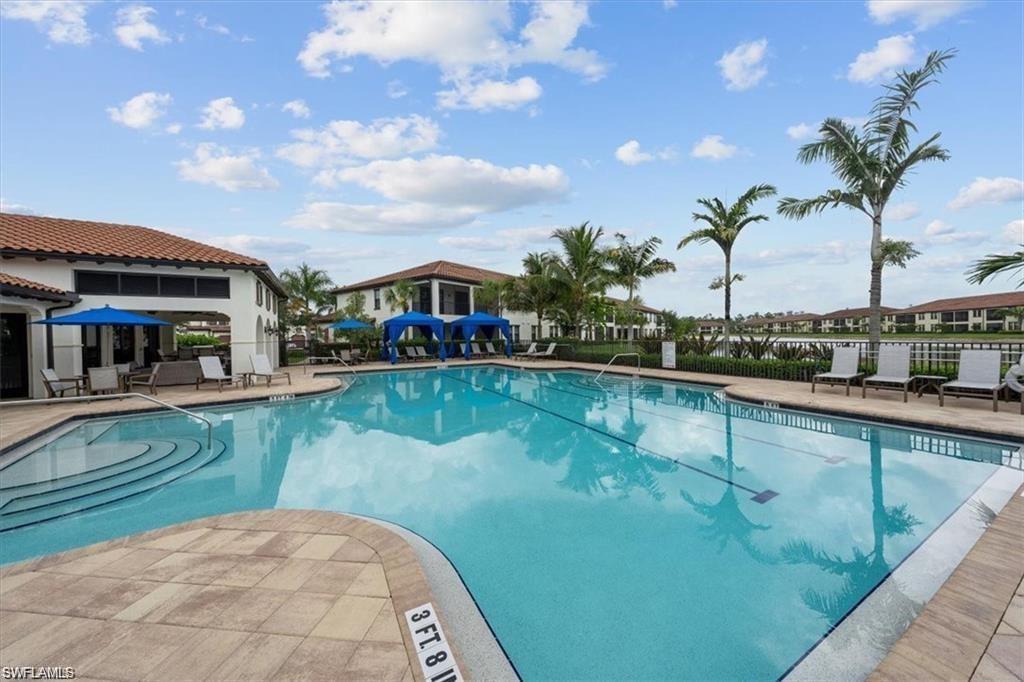 Community pool with a pool deck and shaded areas and seating for sunning.