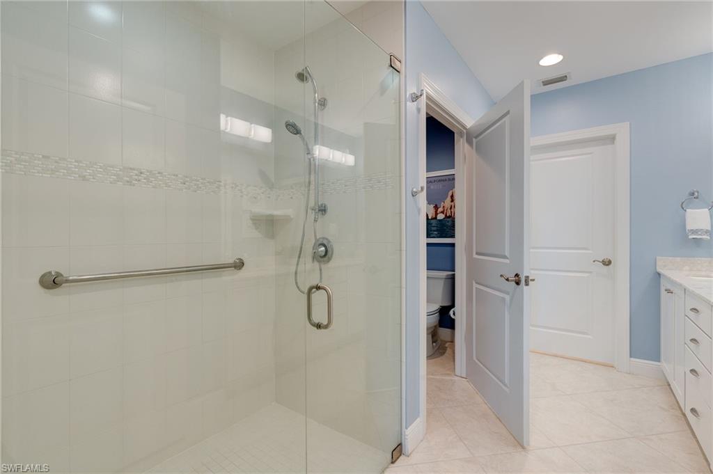 Bathroom featuring a 1/2" thick glass stall shower and separate water closet.