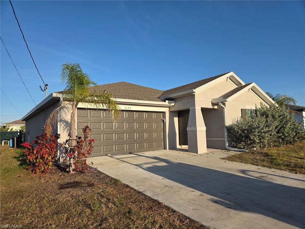 Single story home featuring stucco siding, driveway, an attached garage, and roof with shingles