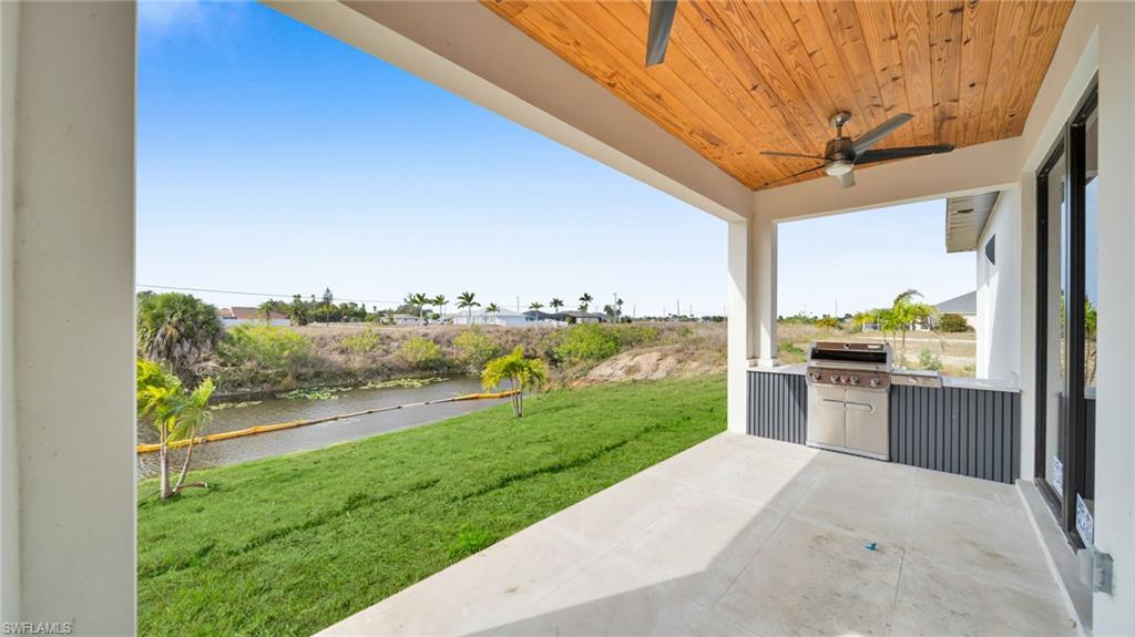 View of patio / terrace featuring ceiling fan, a water view, and grilling area