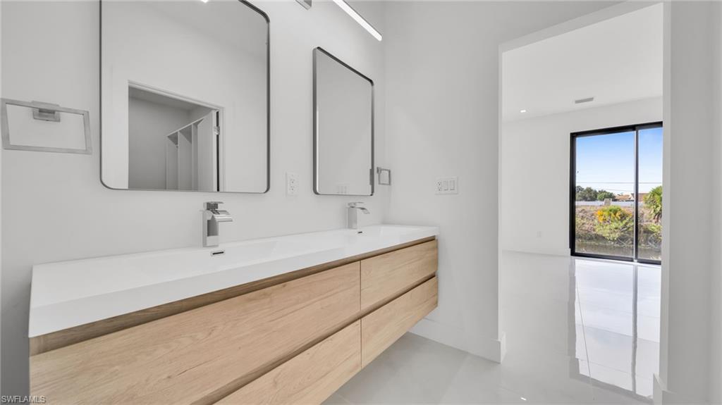 Full bath featuring a shower with shower curtain, double vanity, and recessed lighting