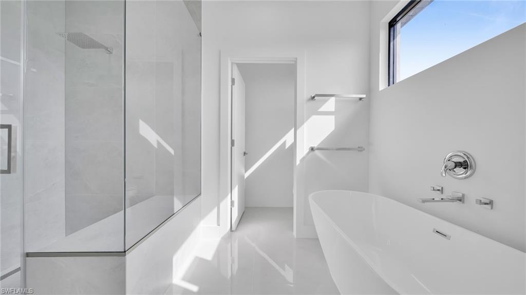 Bathroom featuring a freestanding bath and tiled shower