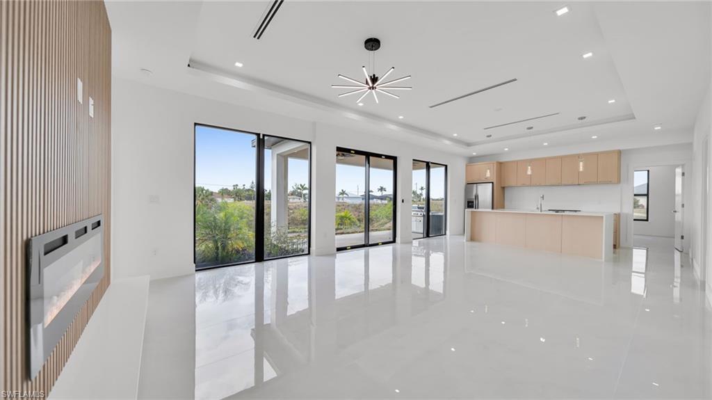 Unfurnished living room with a fireplace, recessed lighting, and a chandelier