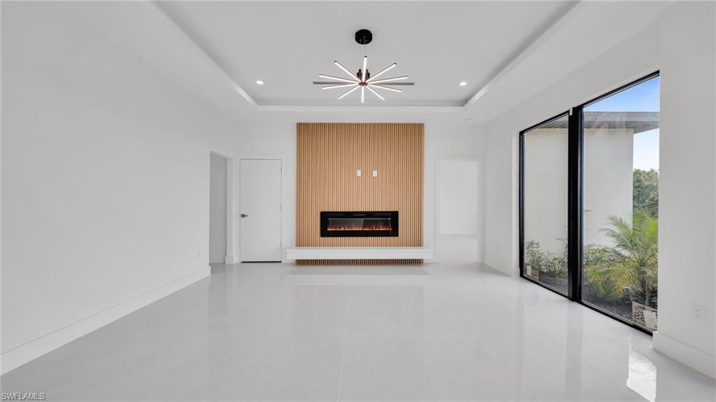 Unfurnished living room with a large fireplace and recessed lighting