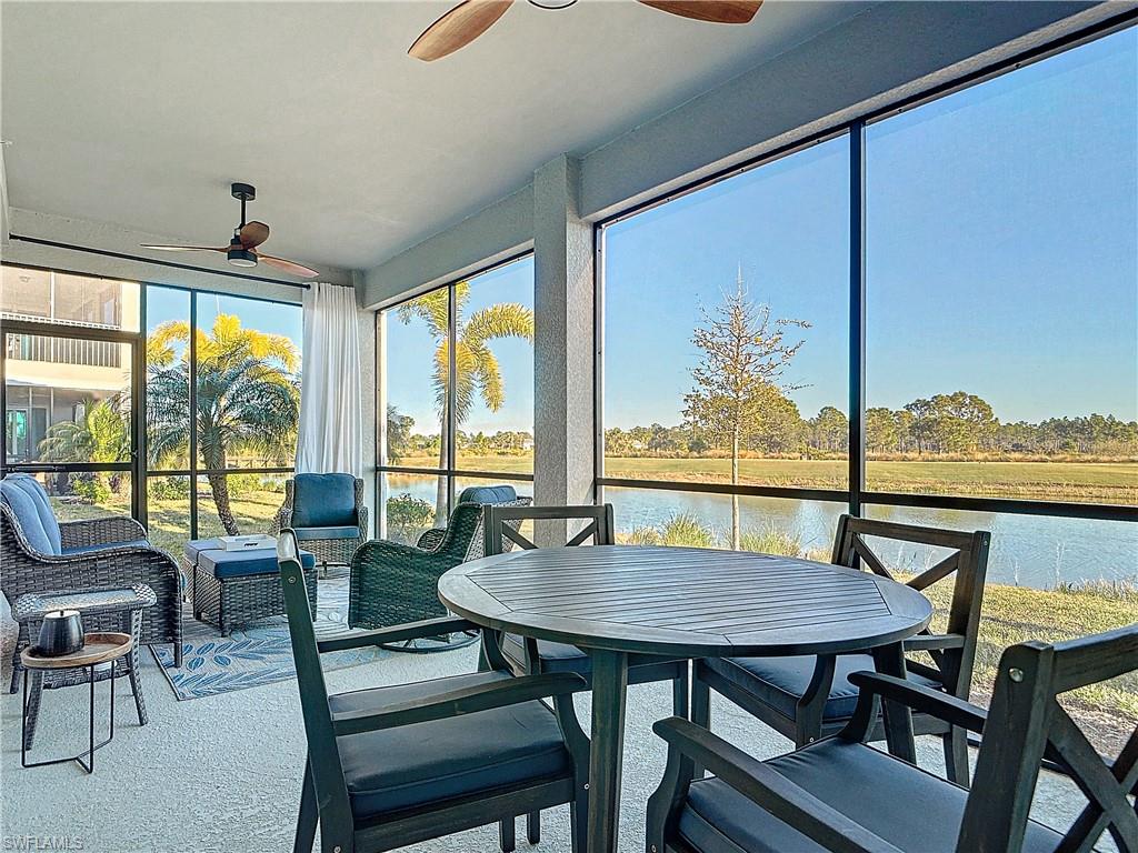 Sunroom / solarium featuring ceiling fan and a water view
