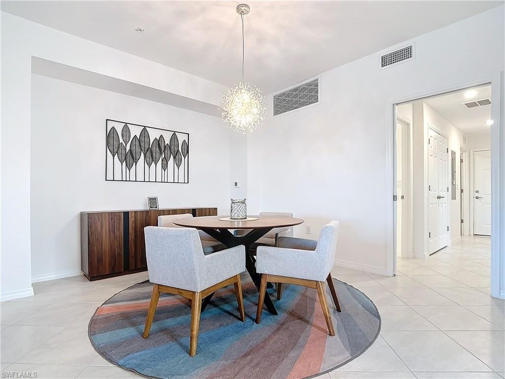 Tiled dining room featuring an inviting chandelier