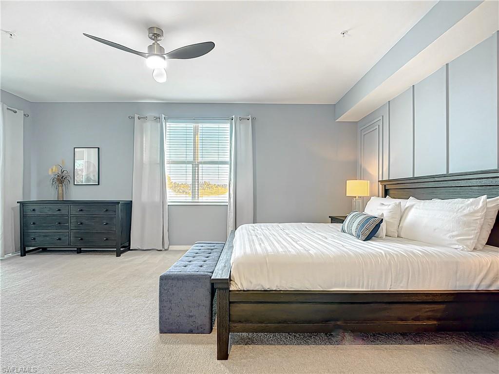Carpeted bedroom featuring ceiling fan